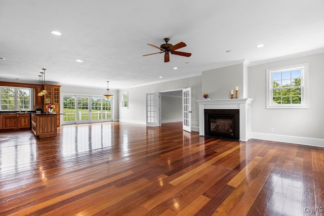 unfurnished living room featuring ornamental molding, ceiling fan, dark hardwood / wood-style floors, and sink