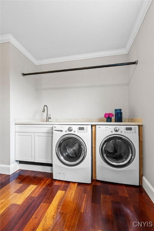 laundry area with cabinets, crown molding, washing machine and clothes dryer, dark hardwood / wood-style flooring, and sink