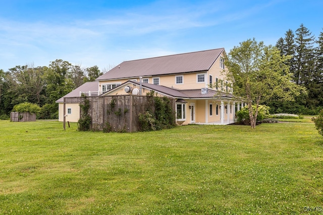 back of property with a yard and a storage shed