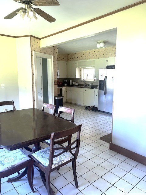 dining area with ceiling fan, sink, and light tile patterned floors