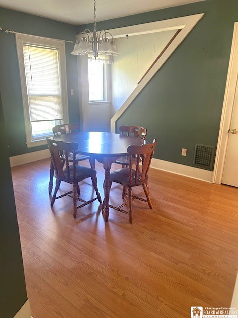 dining room with plenty of natural light, hardwood / wood-style floors, and a chandelier