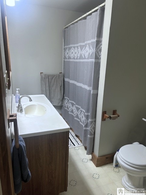 bathroom featuring walk in shower, toilet, and vanity