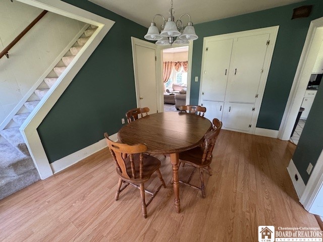 dining area featuring light wood-type flooring and an inviting chandelier