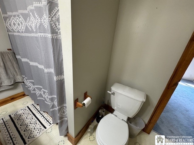 bathroom with toilet and a shower with curtain