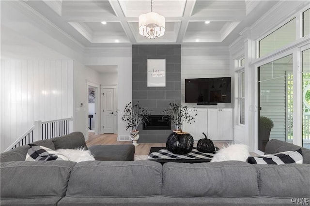 living room featuring coffered ceiling, wood walls, beam ceiling, light hardwood / wood-style floors, and a chandelier