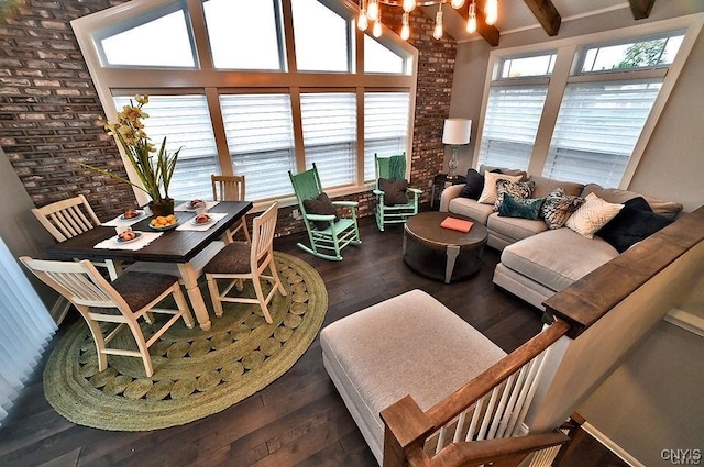 living room with hardwood / wood-style floors, beamed ceiling, and brick wall