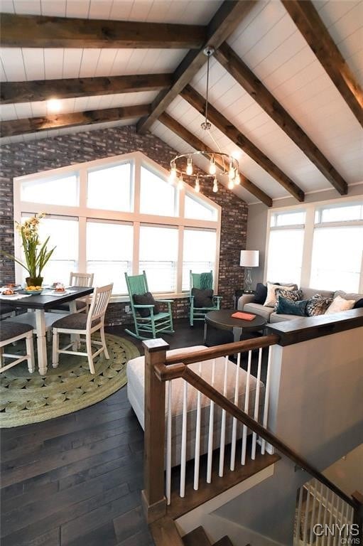 living room with wood-type flooring, lofted ceiling with beams, and brick wall