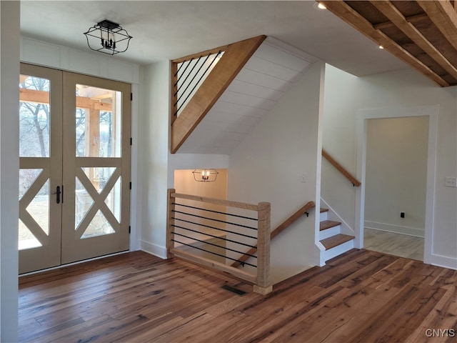 entryway with french doors, dark hardwood / wood-style flooring, plenty of natural light, and lofted ceiling