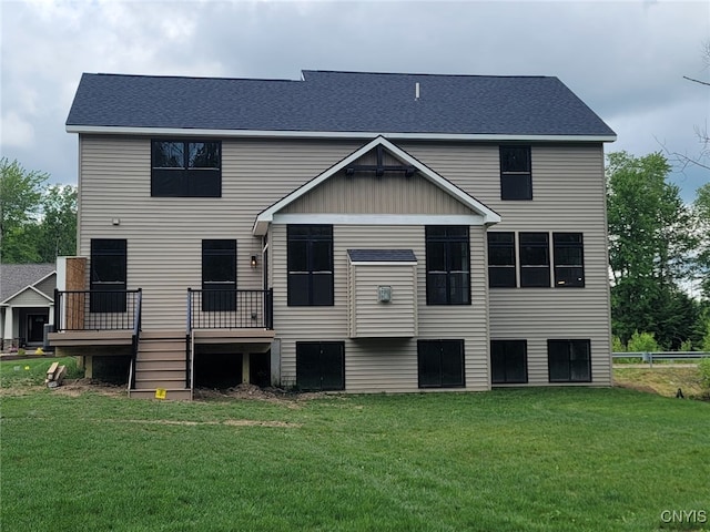 rear view of house with a wooden deck and a lawn