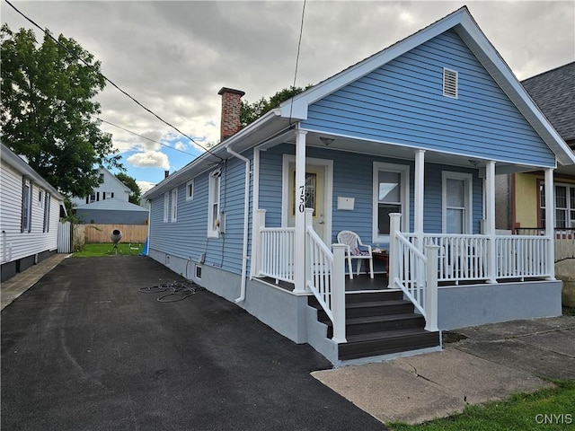 750 Lansing St, Utica, NY 13501 - bungalow-style house featuring covered porch, fence, and a chimney