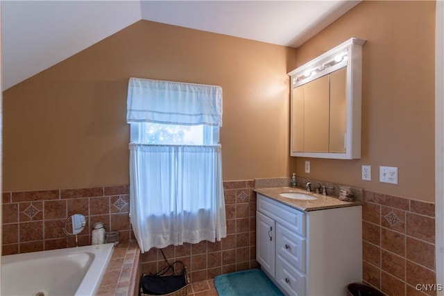 318 Stevens Rd, Gouverneur, NY 13642 - bathroom featuring tile walls, a whirlpool tub, vanity, wainscoting, and lofted ceiling