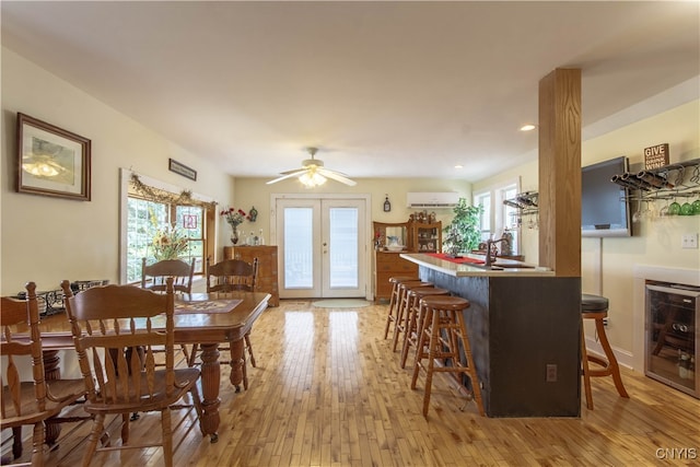 kitchen featuring a wall mounted AC, wine cooler, light hardwood / wood-style flooring, french doors, and ceiling fan