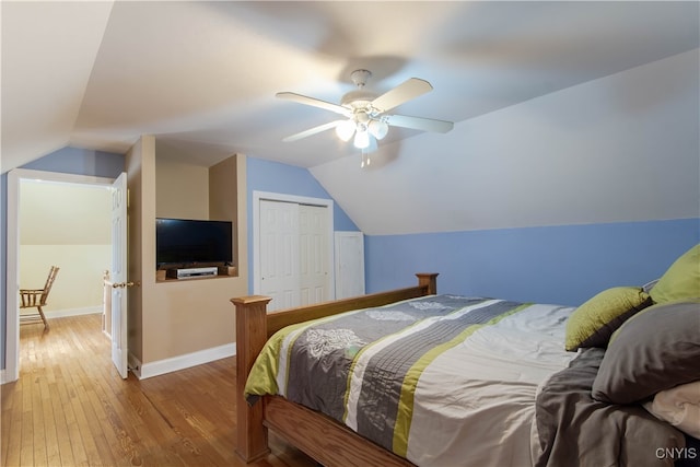 bedroom featuring lofted ceiling, hardwood / wood-style floors, ceiling fan, and a closet