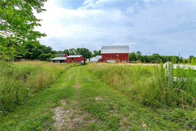 view of yard featuring a rural view and an outdoor structure