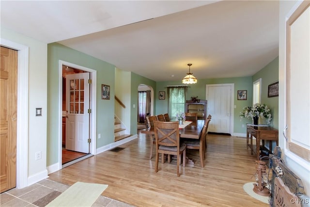 318 Stevens Rd, Gouverneur, NY 13642 - dining area featuring arched walkways, stairs, light wood-style floors, and a chandelier