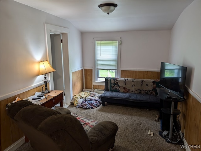 living room with vaulted ceiling, wood walls, and carpet floors