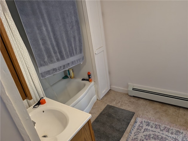 bathroom featuring a baseboard heating unit, a tub, vanity, and tile patterned floors