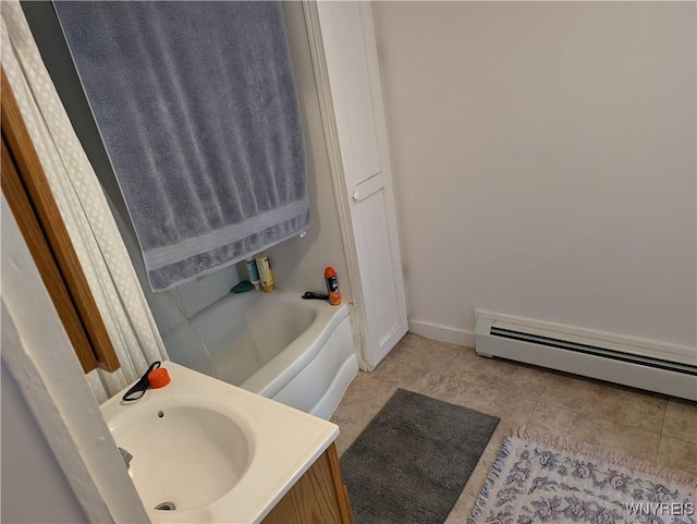 full bath with tile patterned flooring, vanity, baseboards, baseboard heating, and a bath