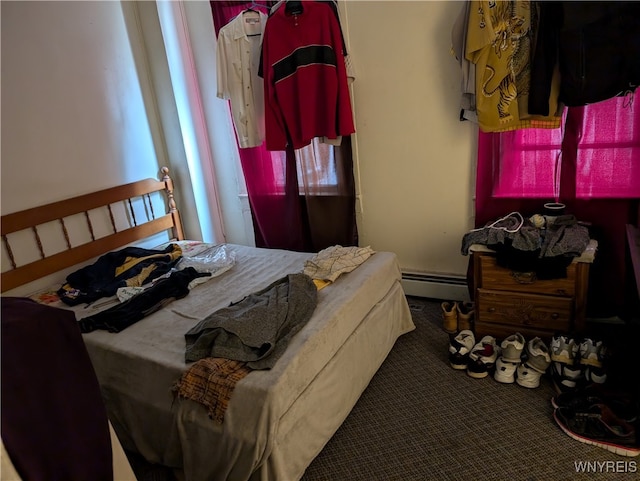 carpeted bedroom featuring a baseboard heating unit