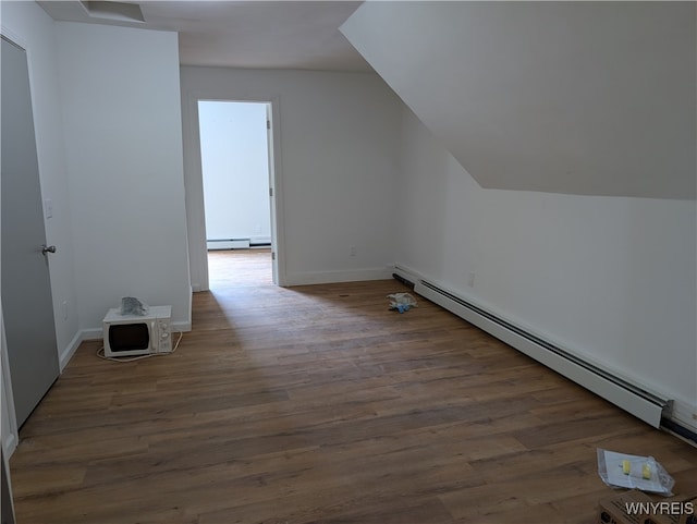 bonus room with baseboard heating, dark hardwood / wood-style flooring, and vaulted ceiling