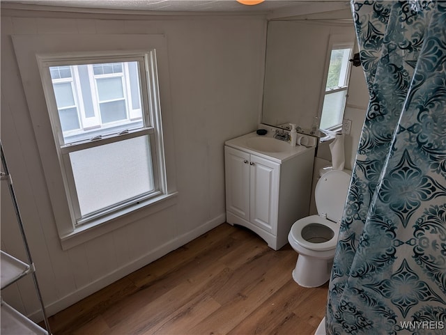 bathroom featuring vanity, toilet, a wealth of natural light, and hardwood / wood-style floors