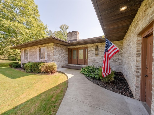 entrance to property with a lawn