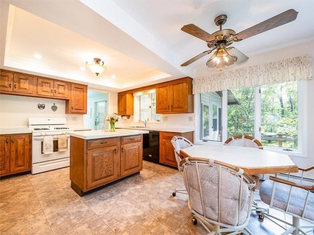 kitchen featuring dishwasher, gas range gas stove, ceiling fan, a raised ceiling, and light tile patterned flooring