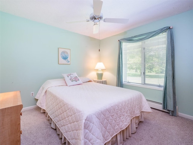 carpeted bedroom with baseboard heating and ceiling fan