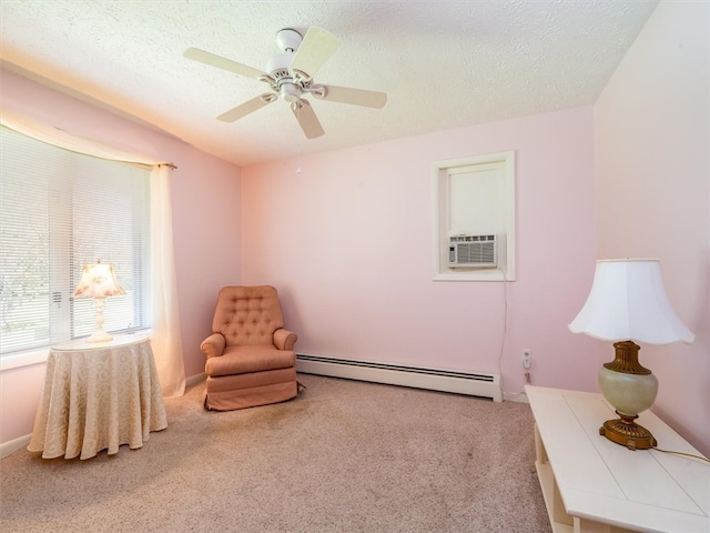 sitting room with ceiling fan, light colored carpet, baseboard heating, and a textured ceiling