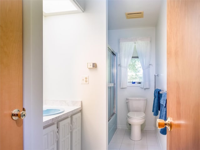 full bathroom featuring shower / bath combination with glass door, vanity, toilet, and tile patterned flooring