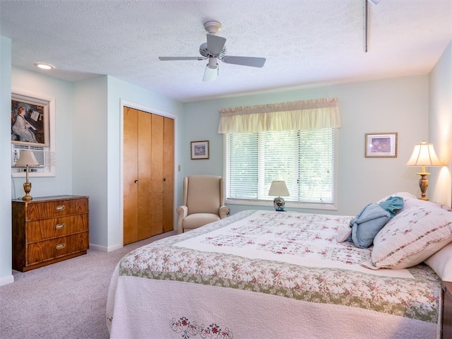 bedroom featuring carpet flooring, a closet, ceiling fan, and a textured ceiling