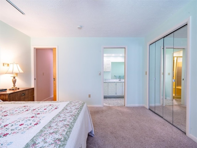 carpeted bedroom featuring a textured ceiling, connected bathroom, and a closet