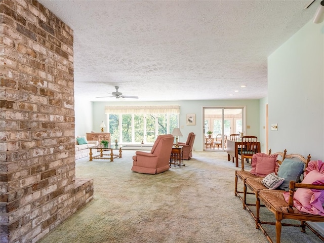 living room featuring a textured ceiling, ceiling fan, and carpet