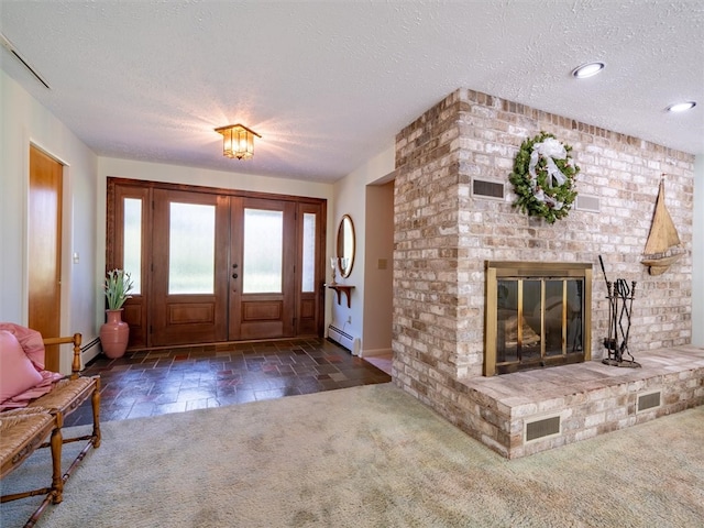 entryway with a fireplace, a textured ceiling, baseboard heating, and dark carpet