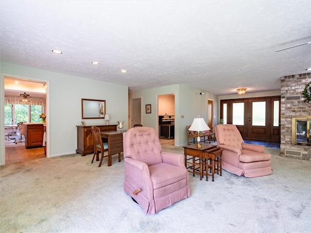 living room featuring a textured ceiling, carpet flooring, and a fireplace