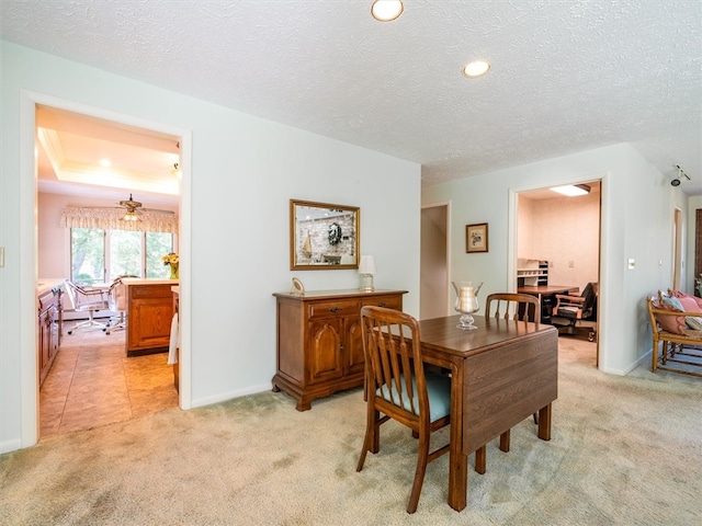 dining room with light colored carpet and a textured ceiling