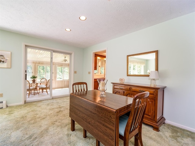 carpeted dining space with a textured ceiling