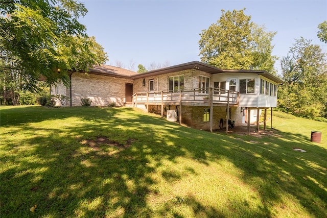 rear view of property featuring a deck and a lawn