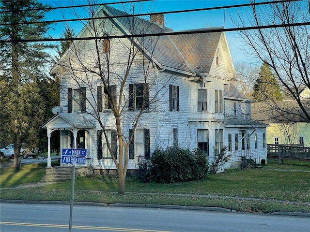 view of front of property featuring a front lawn and a chimney