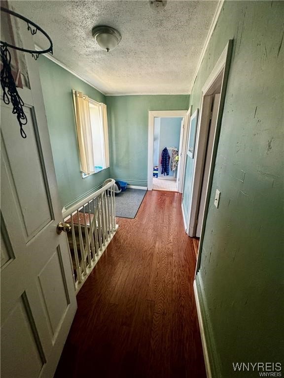 hall featuring a textured ceiling and hardwood / wood-style flooring