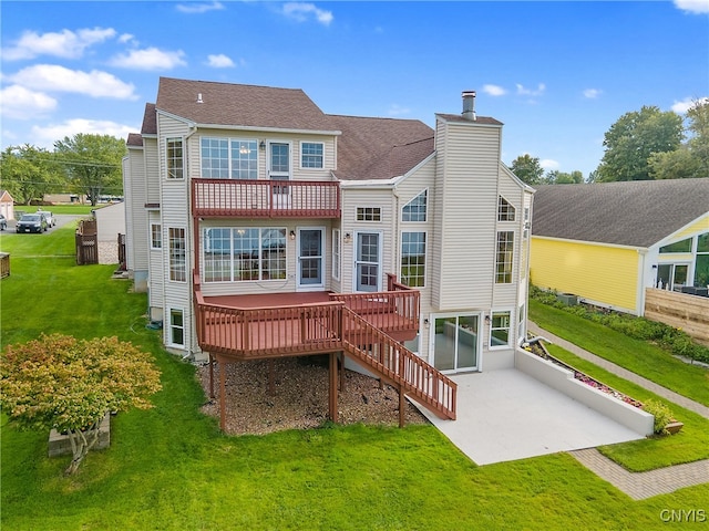 rear view of property featuring a wooden deck and a lawn