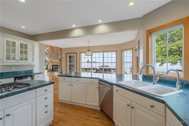 kitchen with appliances with stainless steel finishes, white cabinetry, a healthy amount of sunlight, and sink