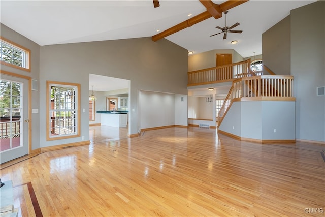 unfurnished living room featuring high vaulted ceiling, beam ceiling, ceiling fan, and light hardwood / wood-style floors