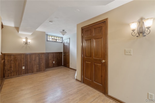 interior space featuring light wood-type flooring and wooden walls