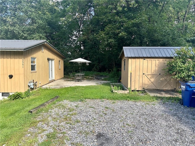 view of yard featuring a patio area and a storage shed