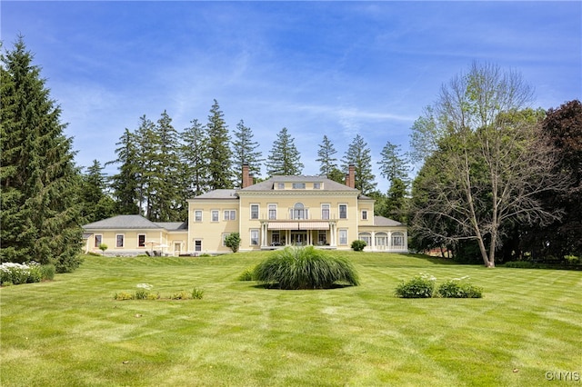 rear view of property featuring a yard