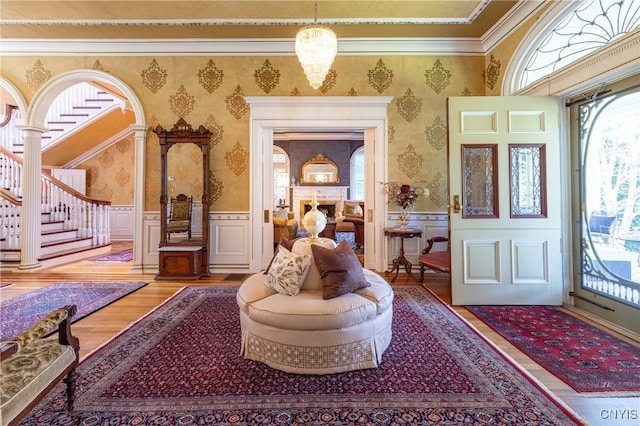 entrance foyer featuring crown molding, an inviting chandelier, and hardwood / wood-style floors