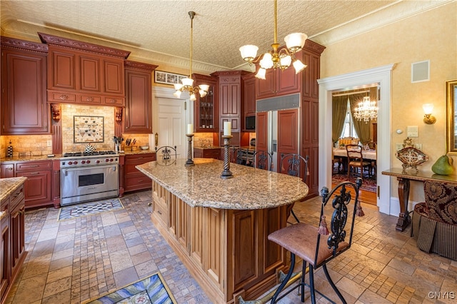 kitchen with hanging light fixtures, a notable chandelier, a kitchen bar, high quality appliances, and a textured ceiling