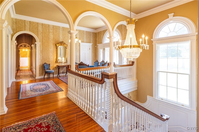 interior space with wood-type flooring, a chandelier, and crown molding