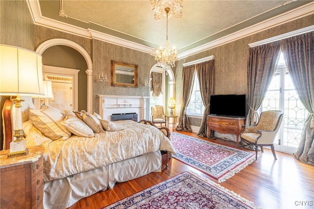 bedroom with crown molding, hardwood / wood-style floors, and a chandelier